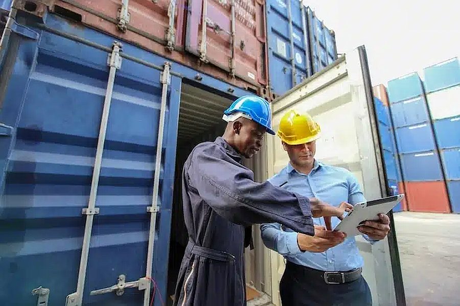 Customs officers and an agent inspecting an open shipping container in Dubai